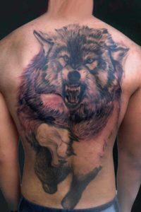 Back Tattoo with a Pouncing Wolf