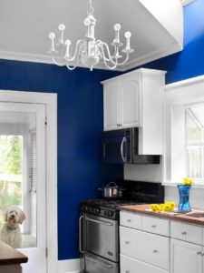 blue kitchen with white backsplash and chandelier