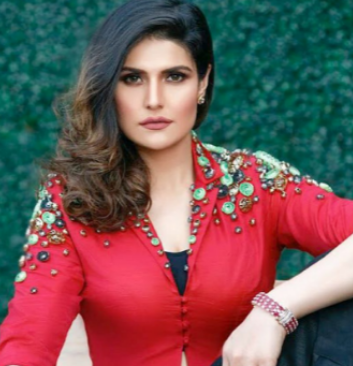 9th Richest Actress zarine khan sitting on a table