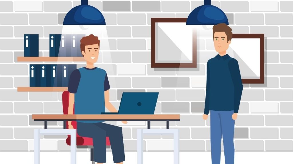 man standing in front of people sitting beside table with laptop